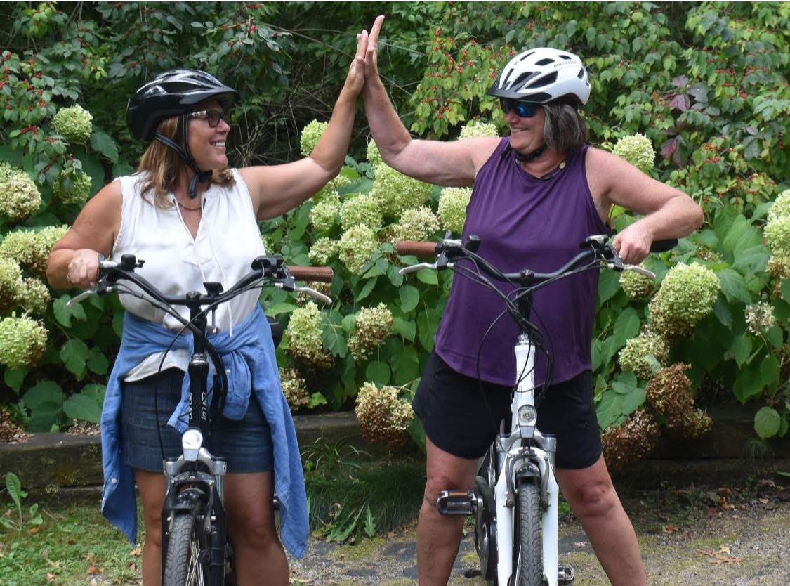 Nancy Bergeron high-fiving on a bike ride